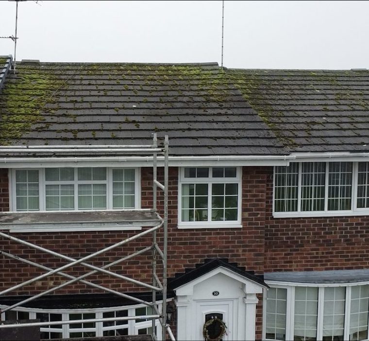 A mossy tiled roof on a mid-terrace house in Crossens, Southport, with an access tower set up at the front