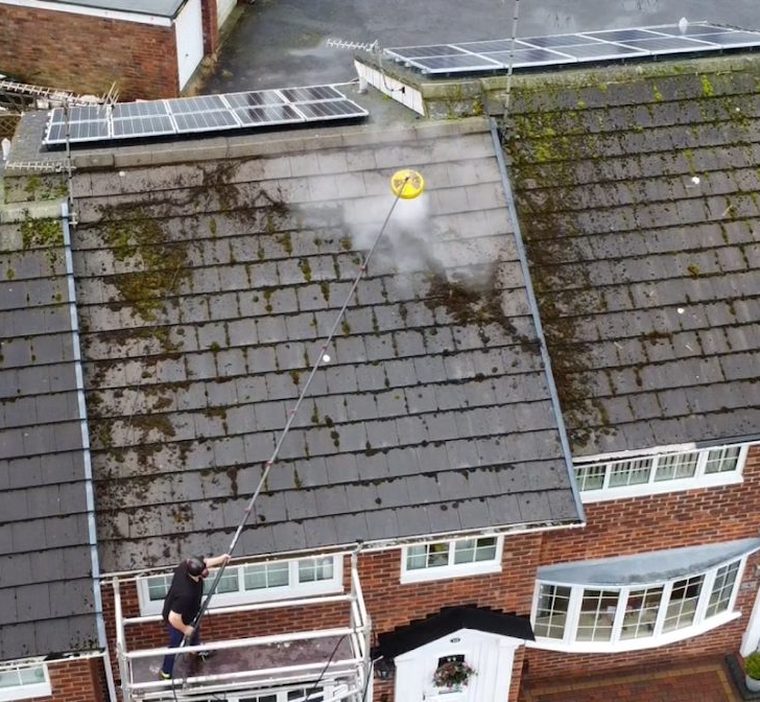 Drone view of a roof being cleaned in Crossens, a clean stripe coming through the moss as the lance works across the tiles