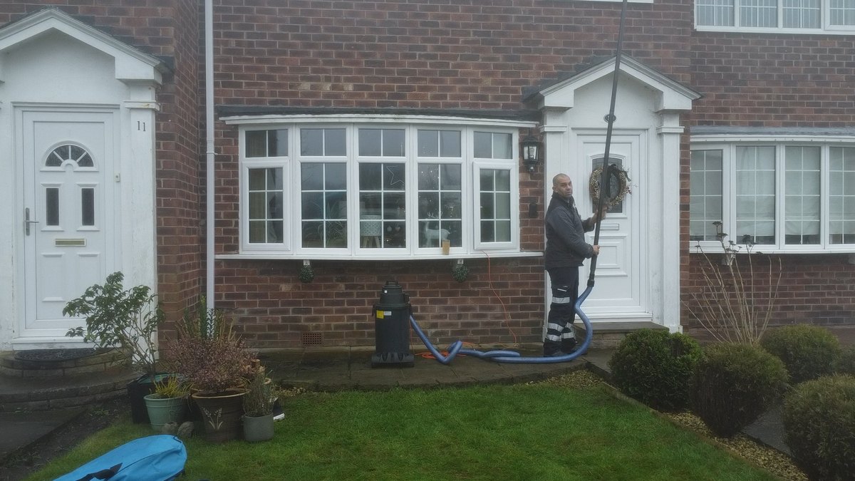No ladders against the house — the gutter cleared from ground level using a telescopic vacuum pole