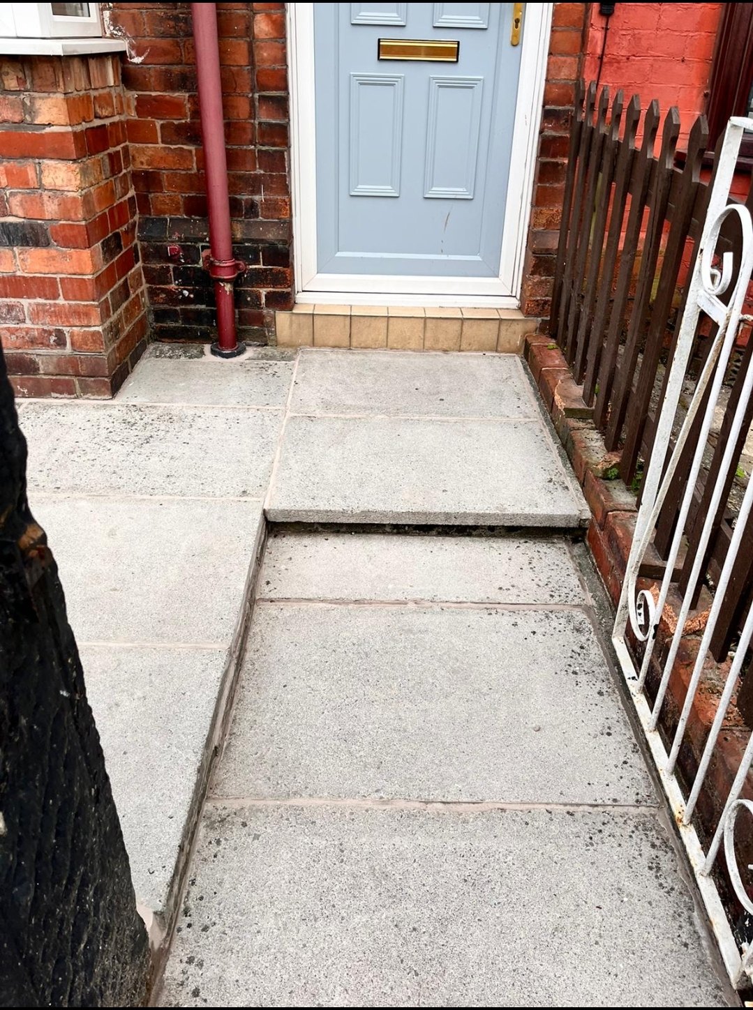 The same front path in Eccleston after repointing, flags clean and the joints filled and crisp