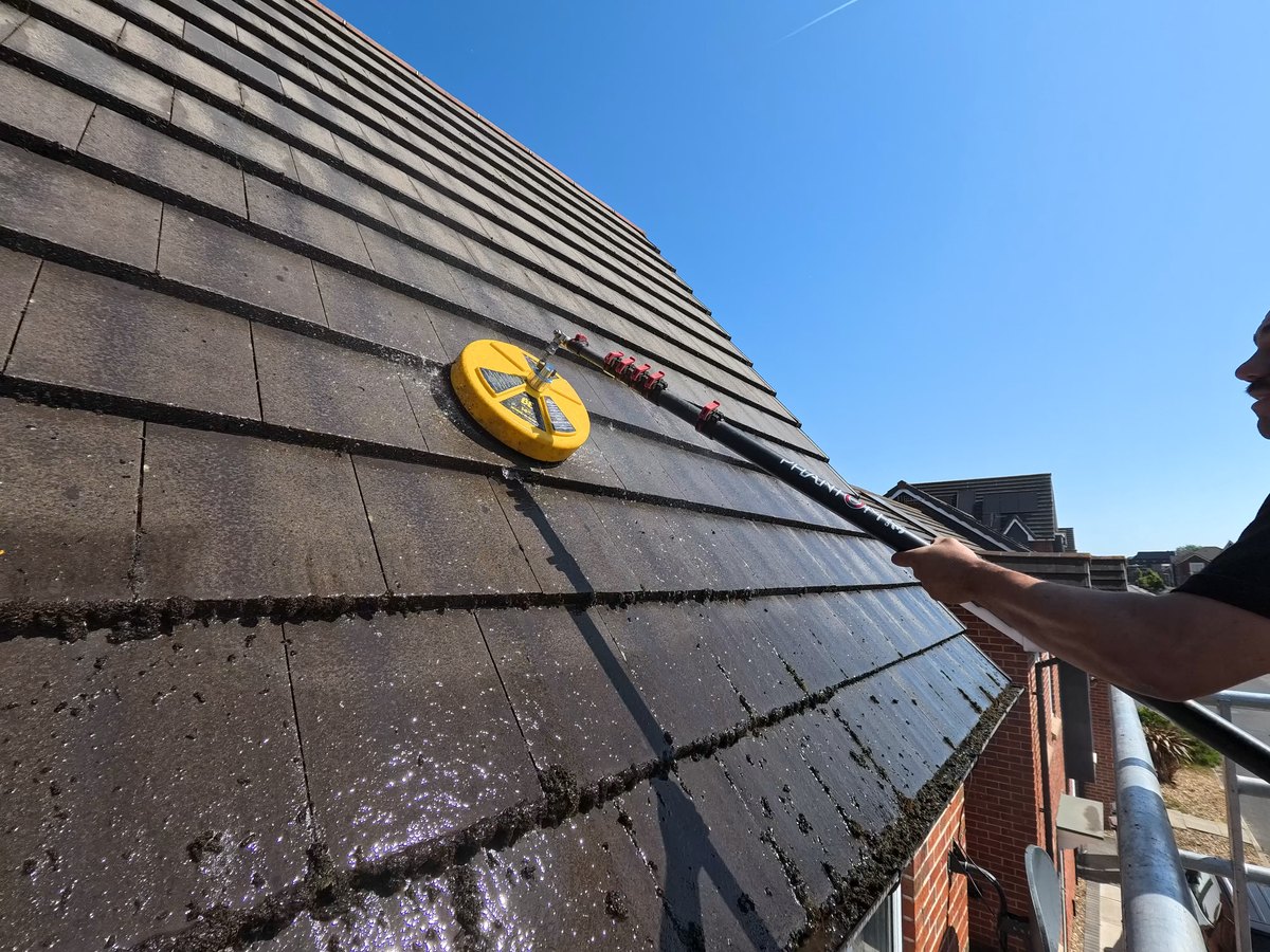 Rotary cleaning head working across mossy roof tiles on a Bootle job