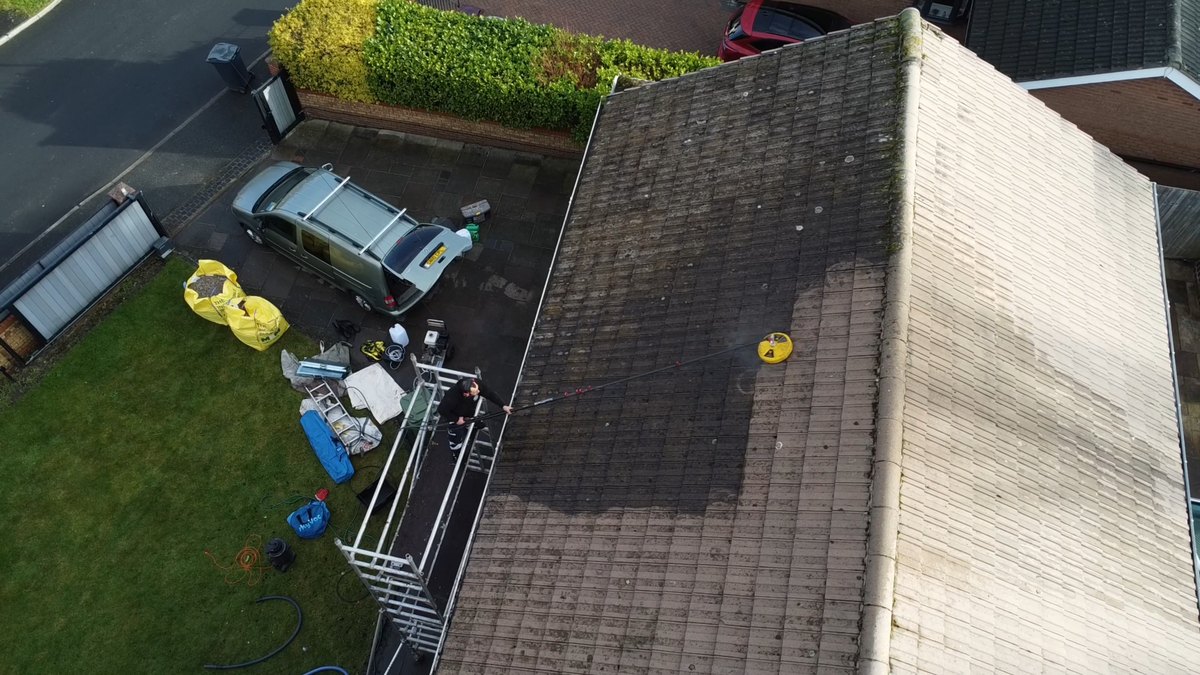 Roof clean underway in Kirkby seen from the drone, cleaned tiles running beside the untouched ones