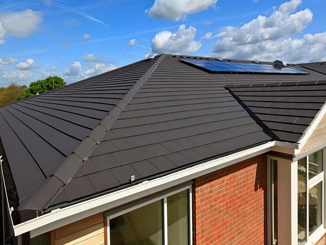 Cleaned roof tiles with solar panels under a blue sky